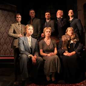 The cast of The Mousetrap arranged around a couch